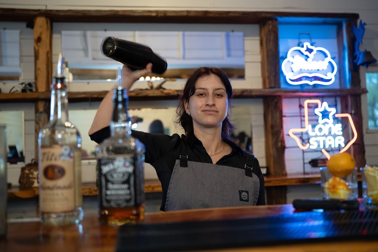 Bartender at Willow Sky Ranch bar with Lone Star neon sign, Hill Country wedding venue near Fredericksburg TX
