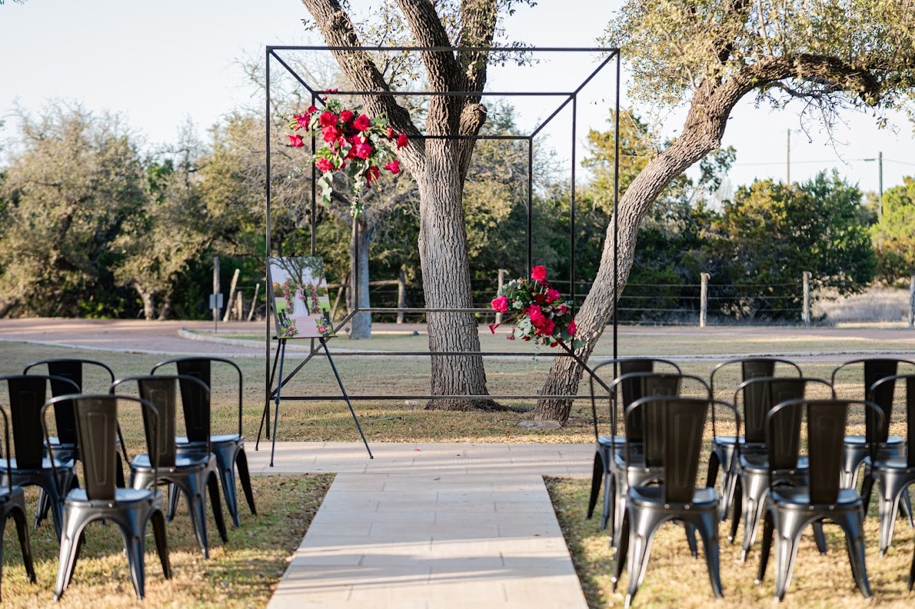 Outdoor ceremony arch with florals between live oak trees at Willow Sky Ranch near Fredericksburg TX