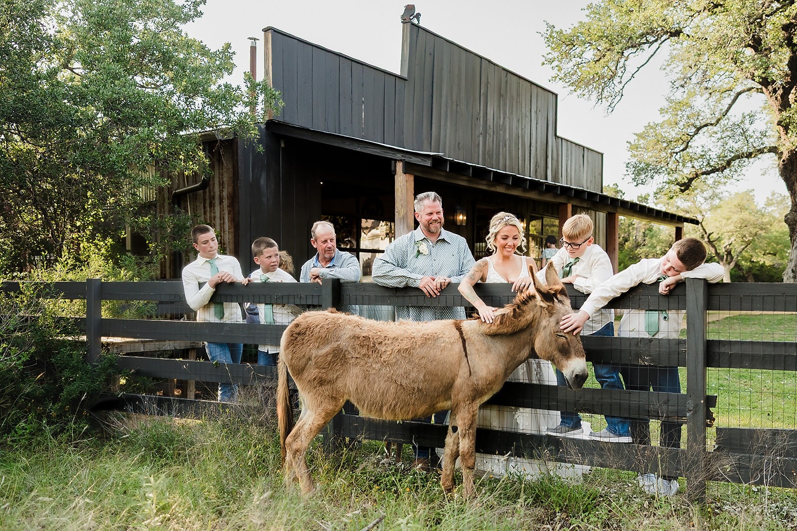Outdoor wedding ceremony under live oak trees at Willow Sky Ranch — bride and groom exchange vows surrounded by pampas grass and Hill Country landscape near Fredericksburg, Texas
