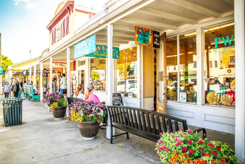 Boutique shops and flower-lined sidewalks on Main Street in Fredericksburg, TX — a bachelorette shopping destination in the Texas Hill Country