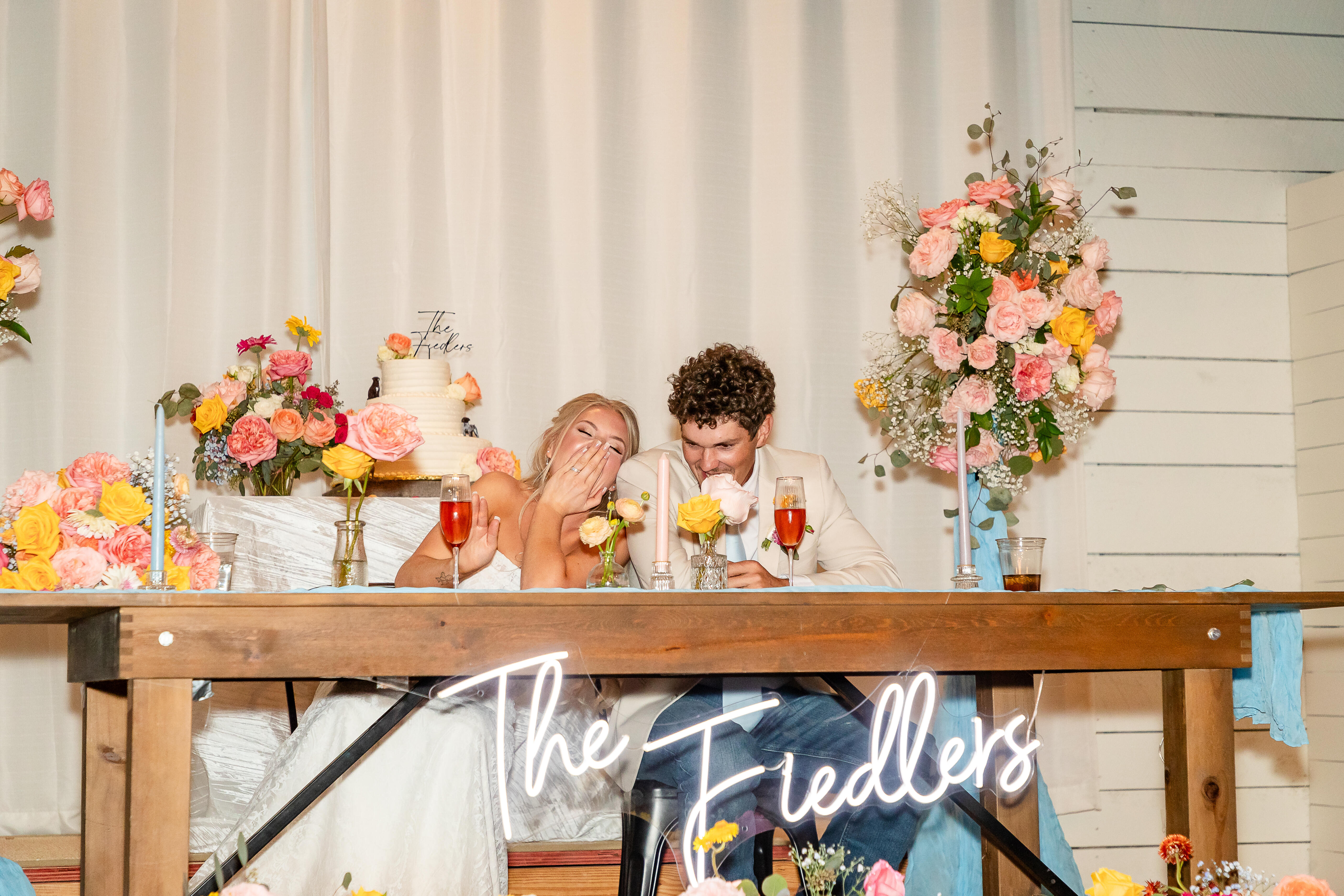 Bride, groom, and bridal party celebrating with a champagne spray at the altar under the live oaks at Willow Sky Ranch — an outdoor wedding ceremony on 75 private Hill Country acres near Fredericksburg, TX
