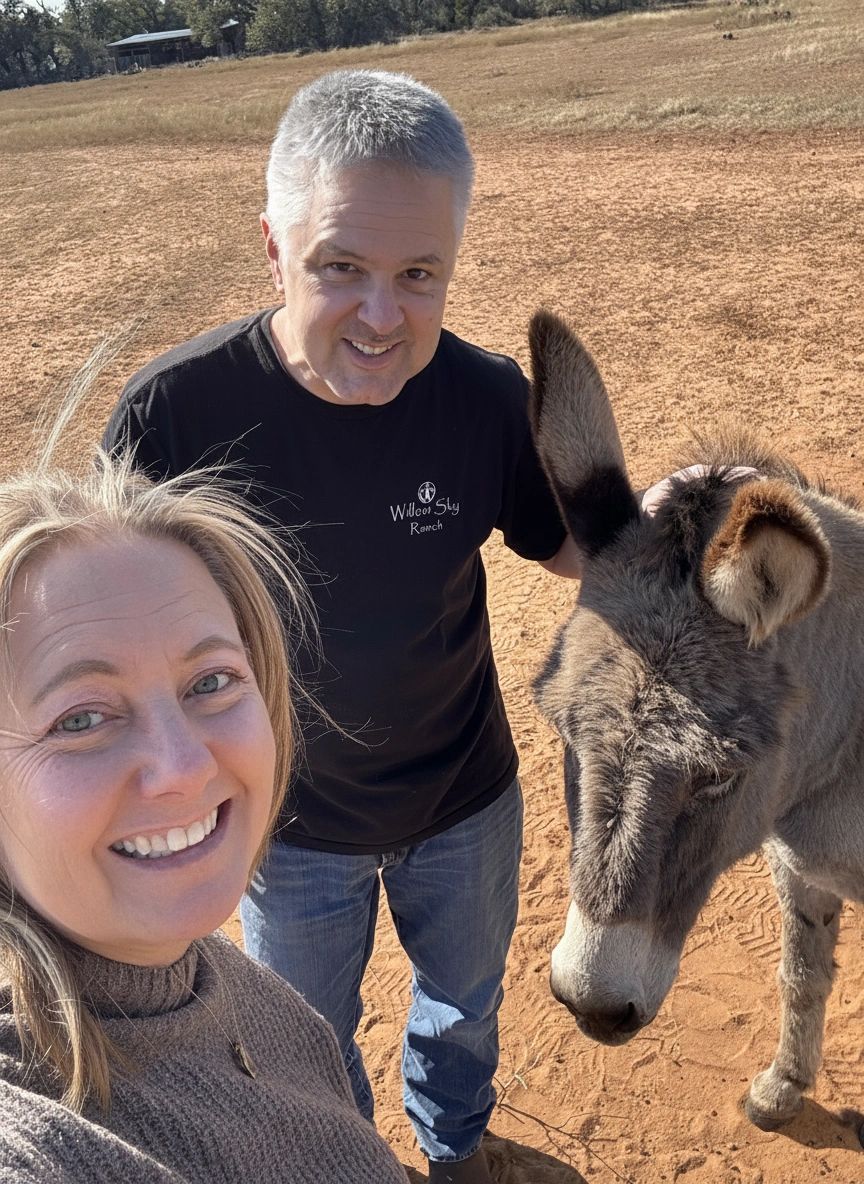 Jennifer and Steve Frezon with a ranch donkey at Willow Sky Ranch, Texas Hill Country